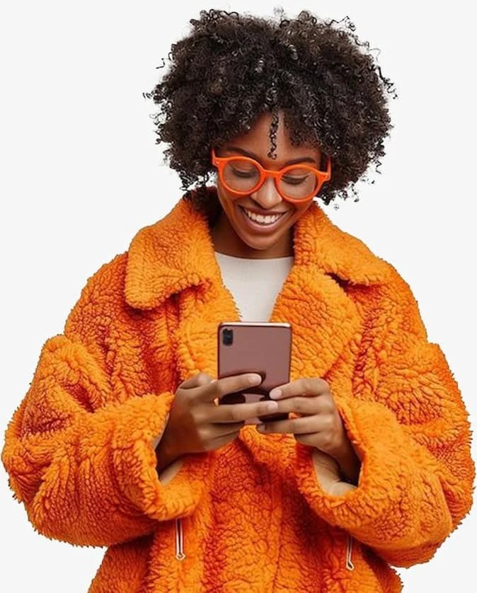 A smiling woman in an orange jacket using her phone